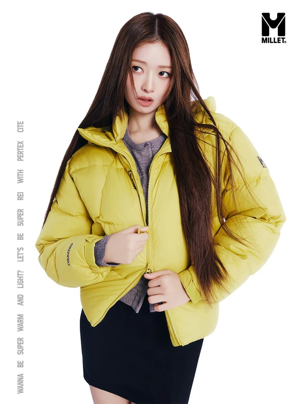 Millet campaign portrait in a bright yellow padded jacket with grey knitwear and a black miniskirt.