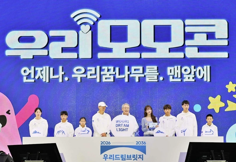Group photograph on the Woori MOMOCON stage, with young athletes and the Woori Dream Light sign.