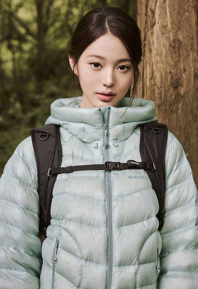 Mint down jacket and backpack in a forest.