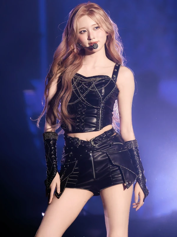 Concert portrait in a black stage outfit under blue and purple lighting