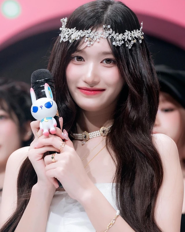 Archive portrait with a silver floral headpiece and a character-decorated microphone.