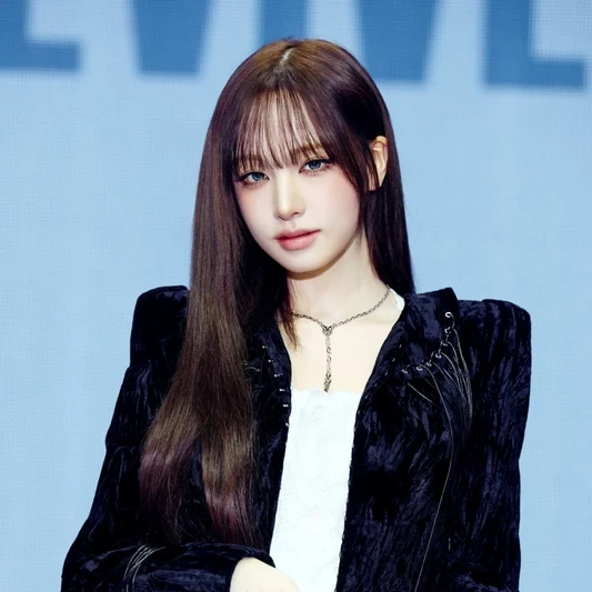 Liz in a black velvet jacket against a pale-blue background