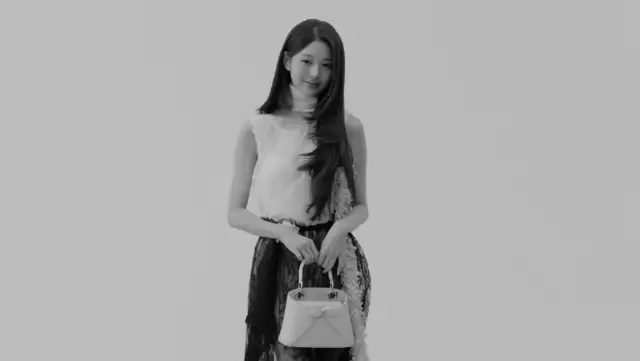 Black-and-white studio shot of Wonyoung holding a handbag