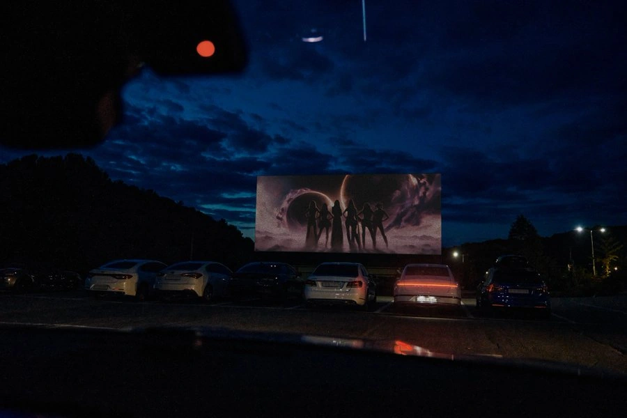Six hero silhouettes projected at a drive-in cinema