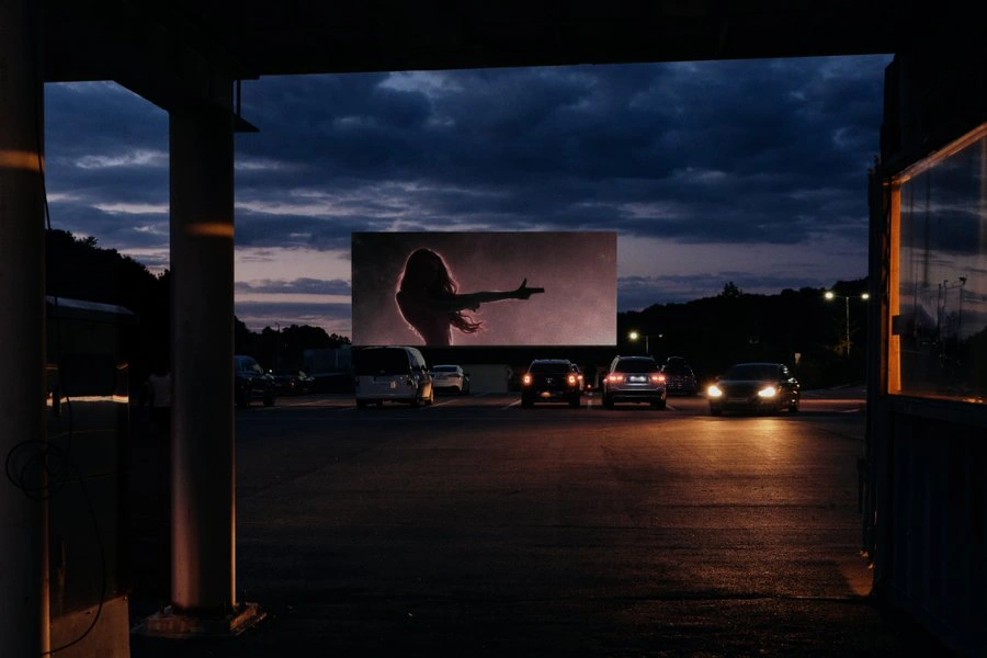 A silhouetted figure on an outdoor screen at dusk