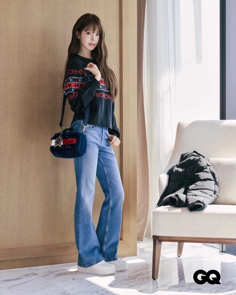 Wonyoung standing in a black puffer, Fair Isle sweater and bootcut jeans