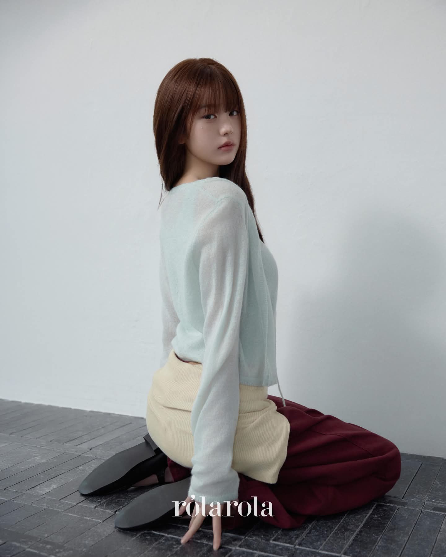 Soft knitwear with burgundy trousers.